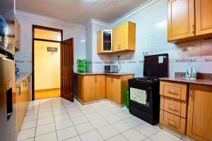 a kitchen with wooden cabinets and a black stove at MANI HOMES in Nairobi