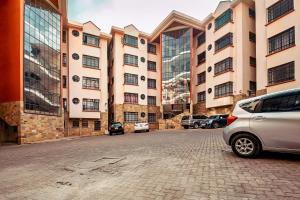 un gran edificio con coches estacionados frente a él en MANI HOMES, en Nairobi