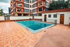 a swimming pool in front of a building at MANI HOMES in Nairobi