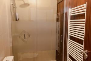 a shower with a glass door in a bathroom at Casa Do Peirão 