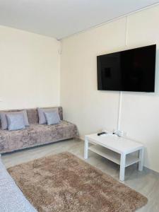 a living room with a couch and a flat screen tv at ΚΑΛΛΙΣΤΟΝ apartment in Neochorópoulon