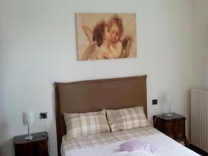 een slaapkamer met een bed met een schilderij aan de muur bij Crespi House in Parabiago