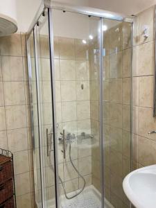 a shower with a glass door in a bathroom at ΚΑΛΛΙΣΤΟΝ apartment in Neochorópoulon