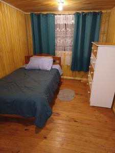 um quarto com uma cama e uma cómoda em Habitación cómoda por día em Valdivia