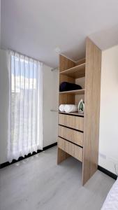 1 dormitorio con cama y estante para libros en Loft 60 Movistar arena 403, en Bogotá