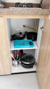 a stove in a cabinet with pots and pans at Loft 60 Movistar arena 403 in Bogotá