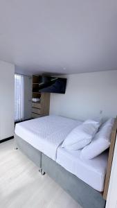 a bedroom with a large white bed in a room at Loft 60 Movistar arena 403 in Bogotá
