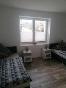 1 Schlafzimmer mit 2 Betten und 2 Fenstern in der Unterkunft Ferienwohnung I Sarrebriese in Bottmersdorf