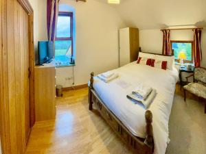 a bedroom with a bed and a tv and a window at Highfields Farm B&B in Stone