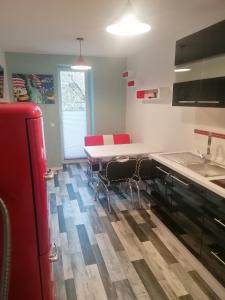 a kitchen with a white table and red chairs at Ferienwohnung I Sarrebriese in Bottmersdorf