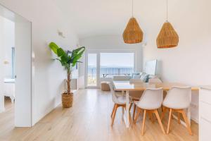 comedor y sala de estar con mesa y sillas en Cap Sa Sal Aquamarina Begur, en Begur