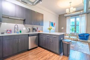 a kitchen with brown cabinets and a blue chair at McCormick Place 420 friendly 3BR/2BA with optional parking in Chicago