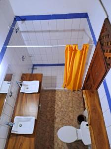 ein Badezimmer mit zwei Waschbecken und einem gelben Vorhang in der Unterkunft Casa Hacienda El Menco in Rivas