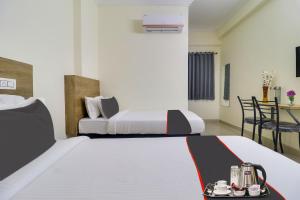 a hotel room with two beds and a table at Collection O Hotel Rio Kondapur Near Rahavendra Colony in Kondapur