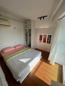 a bedroom with a large bed with pink pillows at Compact Cozy Duplex Studio at Bayan Lepas in Bayan Lepas