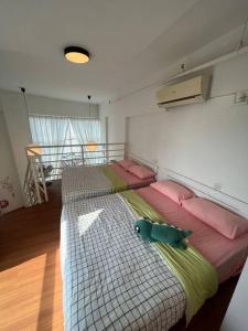 a bedroom with a large bed with pink and green pillows at Compact Cozy Duplex Studio at Bayan Lepas in Bayan Lepas