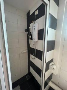 uma casa de banho com uma parede listrada a preto e branco em Compact Cozy Duplex Studio at Bayan Lepas em Bayan Lepas