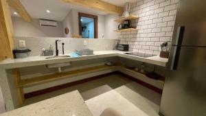 a kitchen with a sink and a refrigerator at Loft novo em Morro de São Paulo in Morro de São Paulo