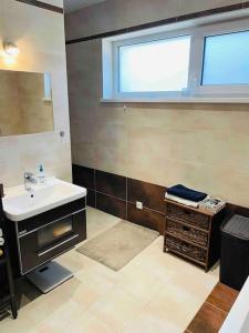 a bathroom with a sink and a mirror at Dom v kľudnej časti Senca s vírivkou / business & relax / in Senec