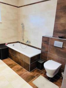 a bathroom with a bath tub and a toilet at Dom v kľudnej časti Senca s vírivkou / business & relax / in Senec