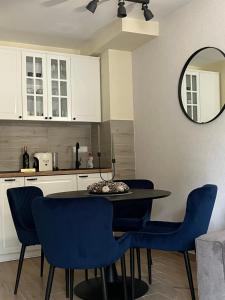 セルビアディヴツィバレにあるApartman Aspen Divcibareのキッチン(テーブル、青い椅子、鏡付)