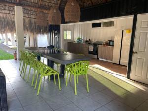 eine Küche mit einem Tisch und grünen Stühlen im Zimmer in der Unterkunft Ocean fronthouse in Salinitas in Acajutla