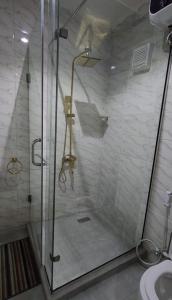 a shower with a glass door in a bathroom at Iyoba Apartment in Abuja