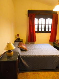 1 dormitorio con 1 cama con lámpara y ventana en Descanso Serrano in 