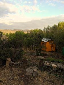 una casa naranja en medio de un campo en Casita de Montaña en Cosquín
