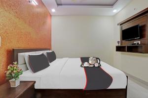 a hotel room with a bed with a tea set on it at Collection O Hotel Premnagar Heights in Dehradun