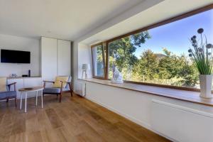 uma sala de estar com uma grande janela e uma mesa em La Loge des Volcans - Vue Puy De Dôme em Saint-Genès-Champanelle