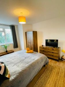 a bedroom with a large bed and a flat screen tv at The Cwtch - Apartment in Cardiff/Penylan in Cardiff