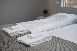 1 cama con 2 toallas blancas en el suelo en Kornmúli, en Búdardalur