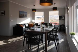 een eetkamer en een woonkamer met een tafel en stoelen bij Kornmúli in Búðardalur