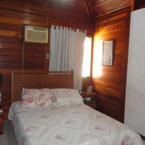 a bedroom with a bed in a wooden room at Cakau House - espaço amplo e aconchegante in Maricá
