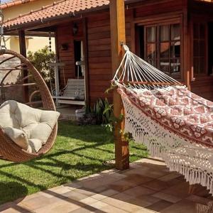 a hammock in a yard next to a house at Cakau House - espaço amplo e aconchegante in Maricá