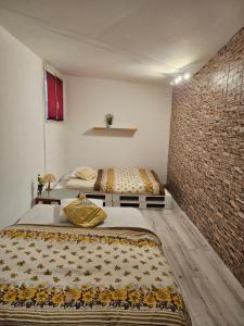twee bedden in een kamer met een bakstenen muur bij Princess marfil in Biel