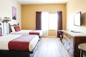 um quarto de hotel com duas camas e uma secretária em Ohkay Hotel Casino em San Juan Pueblo