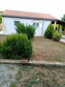 ein Zaun vor einem Haus mit Büschen in der Unterkunft Gabriella in Valtura