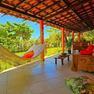 een hangmat hangend aan een pergola op een patio bij Villa Mar a Vista - Suite Alamanda in Cumuruxatiba