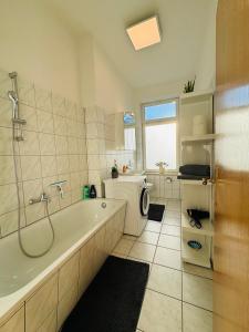 ein Badezimmer mit einer Badewanne und einer Waschmaschine in der Unterkunft Attraktive Wohnung im schönen Hinterhof in Schwerin