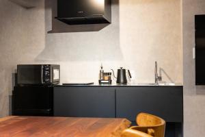 a kitchen with a table and a microwave at Lumiebelle - Vacation STAY 35183v in Kochi