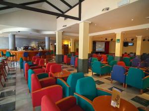 a restaurant with colorful chairs and tables and a bar at Hotel Servigroup Pueblo Benidorm in Benidorm
