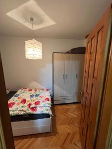 a bedroom with a bed and a closet and a door at Stan na dan Apartman TRG in Derventa
