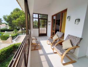 een veranda met stoelen en een balkon met uitzicht bij Acogedor apartamento con vistas 80 m2 in Alcossebre