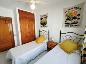 een slaapkamer met 2 bedden en een bord aan de muur bij Acogedor apartamento con vistas 80 m2 in Alcossebre