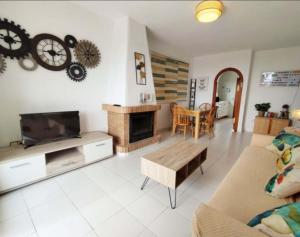 een woonkamer met een bank en een klok aan de muur bij Acogedor apartamento con vistas 80 m2 in Alcossebre