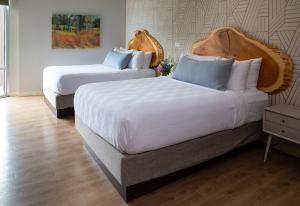a hotel room with two beds with white sheets at Delamar Traverse City in Traverse City