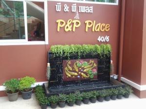 una señal para un lugar de papaya con un montón de plantas en P and P Place en Kanchanaburi