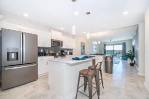 a kitchen with white cabinets and stainless steel appliances at 3171-204AZ STOREY LAKE, CONDO 2/2 LAKE VIEW in Kissimmee